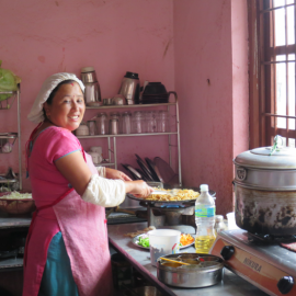 A women of the community preparing traditional food - Women like her will benefit from the grant